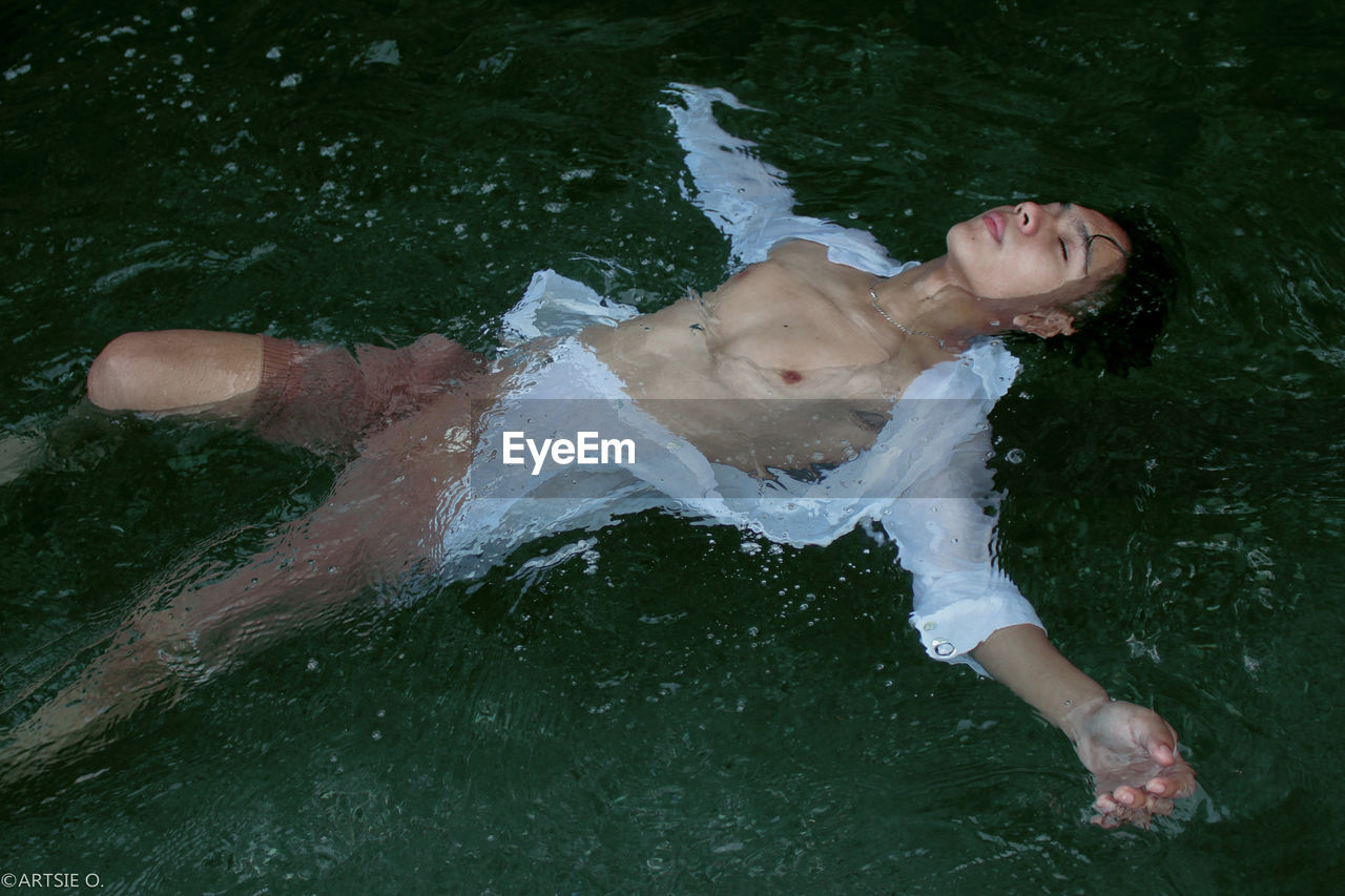 High angle view of young man swimming in lake