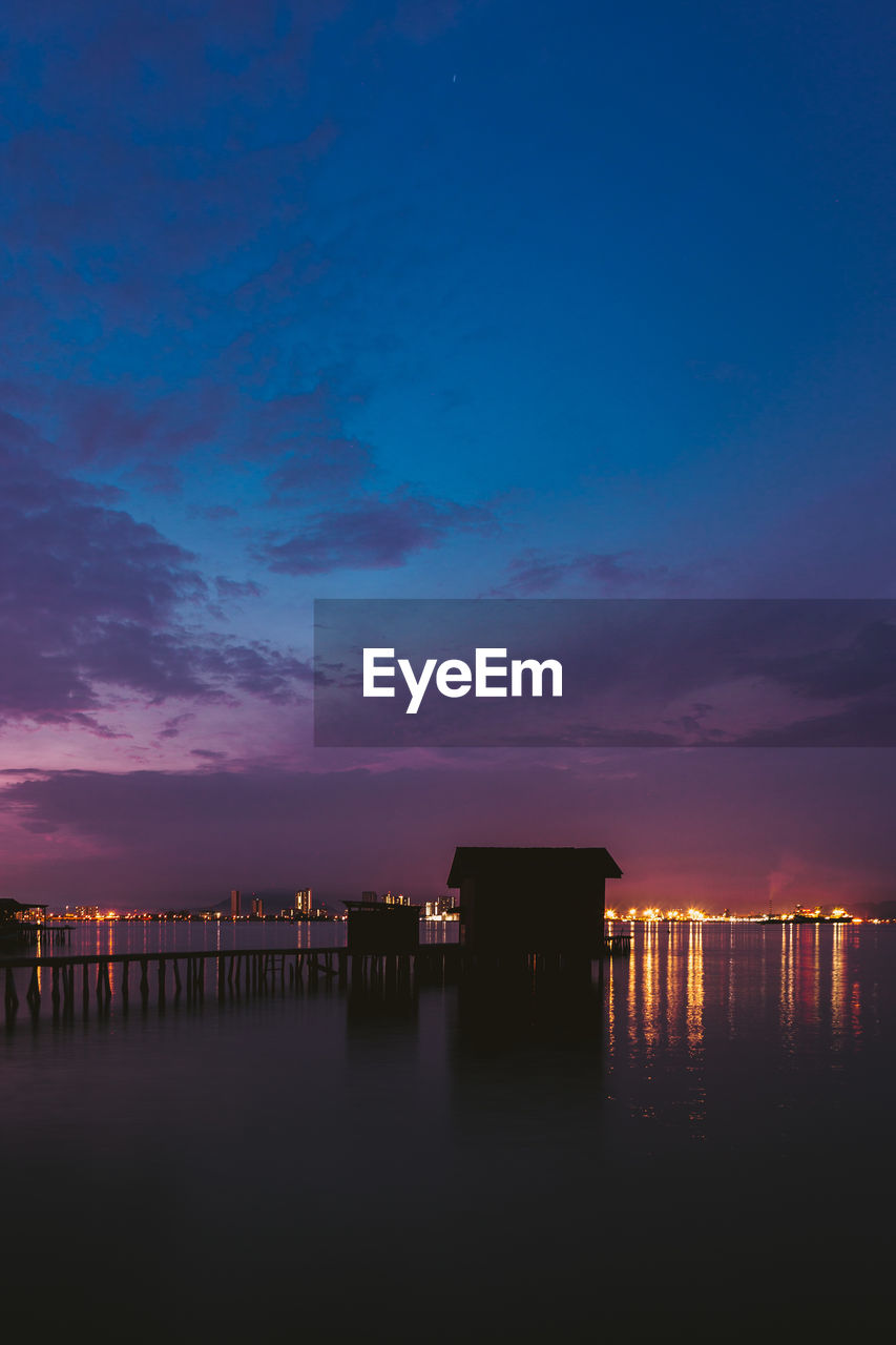 SCENIC VIEW OF SEA AGAINST BLUE SKY AT SUNSET