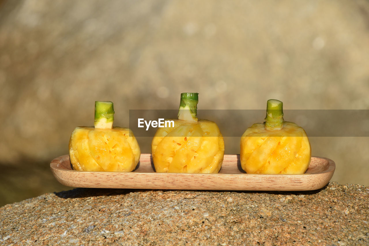 Close-up of pineapples in tray on rock