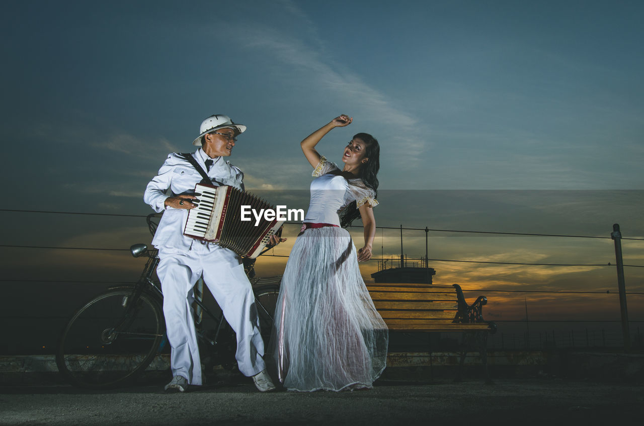 Man playing musical instrument standing by dancer