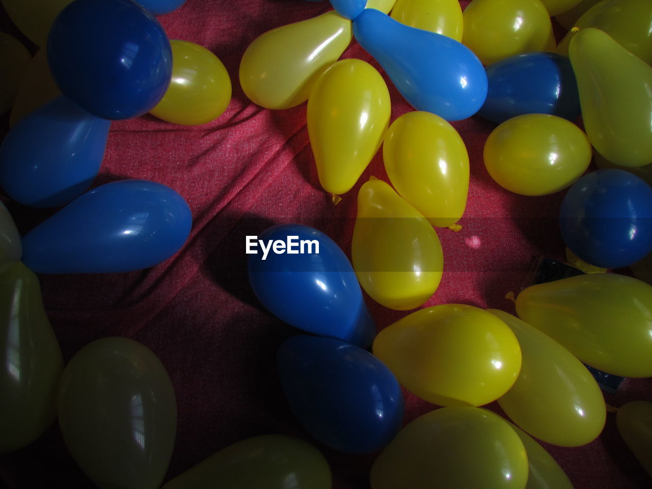 CLOSE-UP OF MULTI COLORED BALLOONS AGAINST BLUE SKY