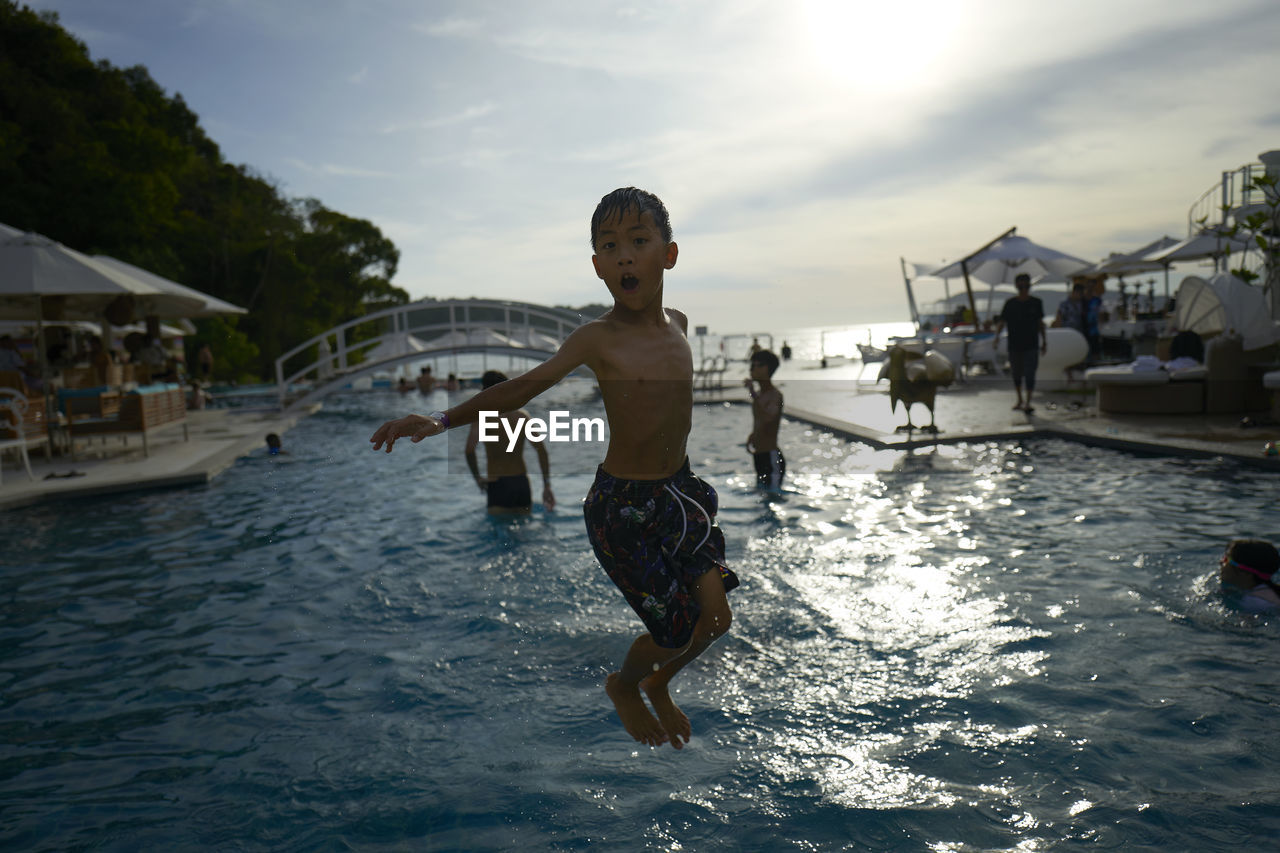 Full length of boy jumping in swimming pool