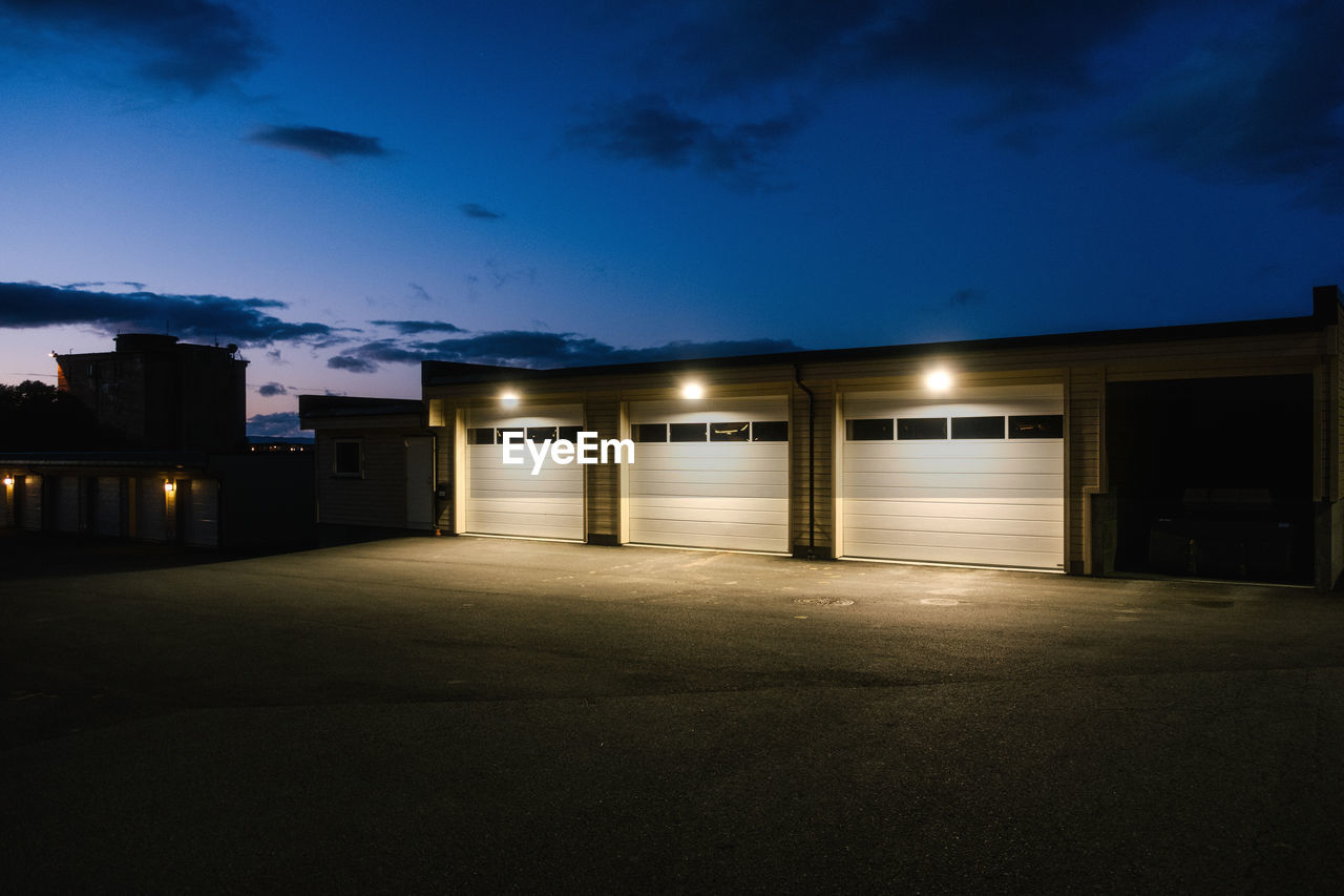 Illuminated residential parking garage against sky at night 