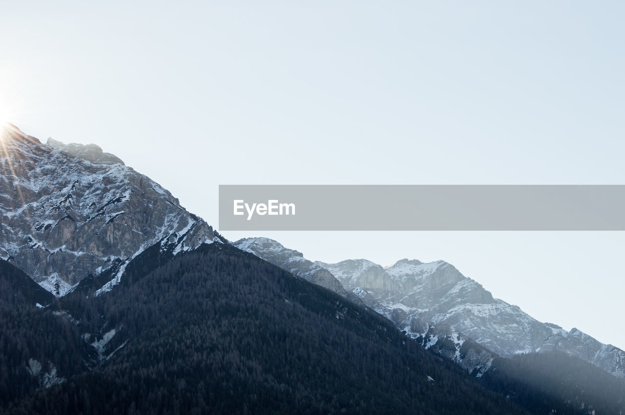 Scenic view of snow covered mountains against clear sky