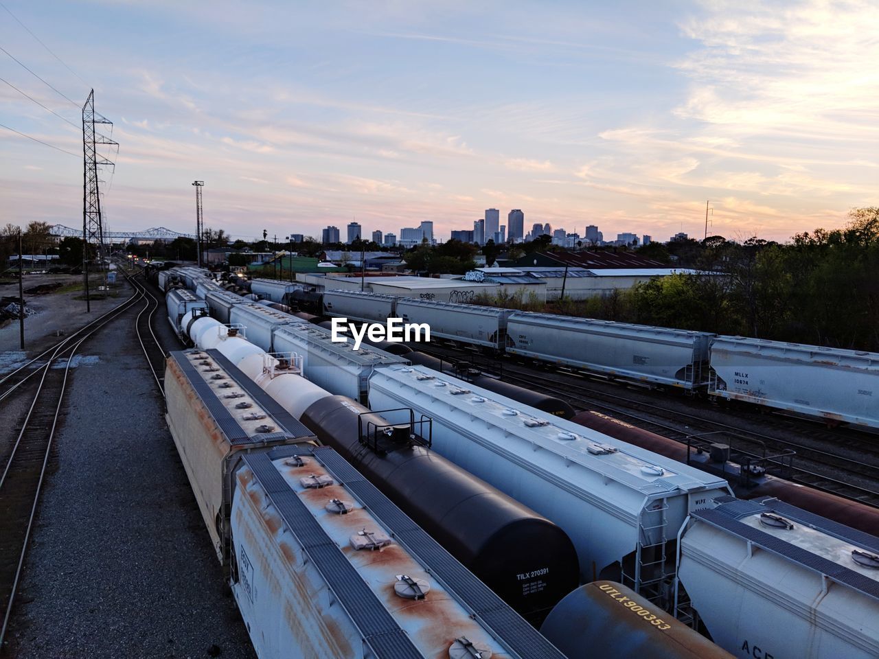 Trains on railroad tracks against sky during sunset