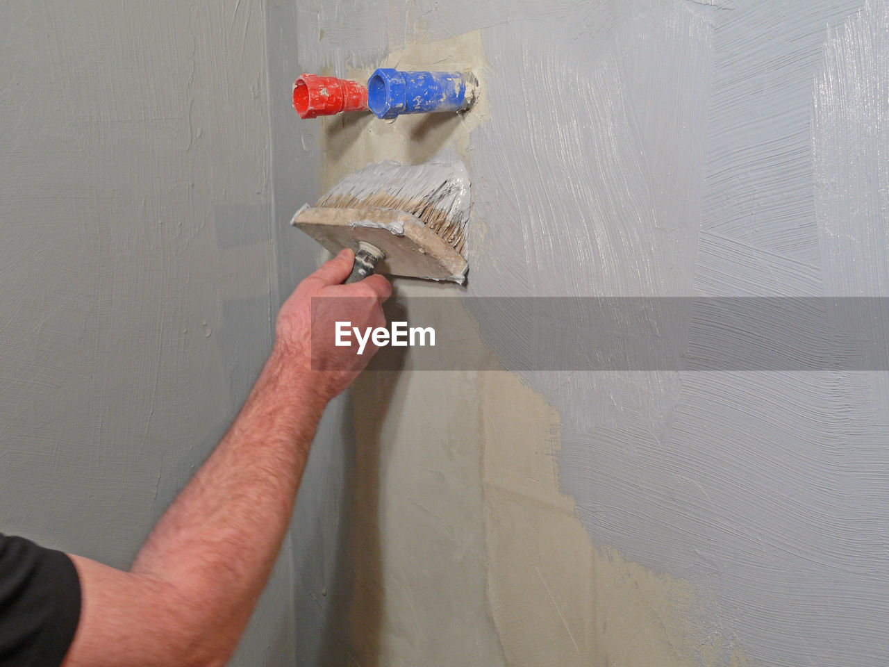 Midsection of man working against wall at home