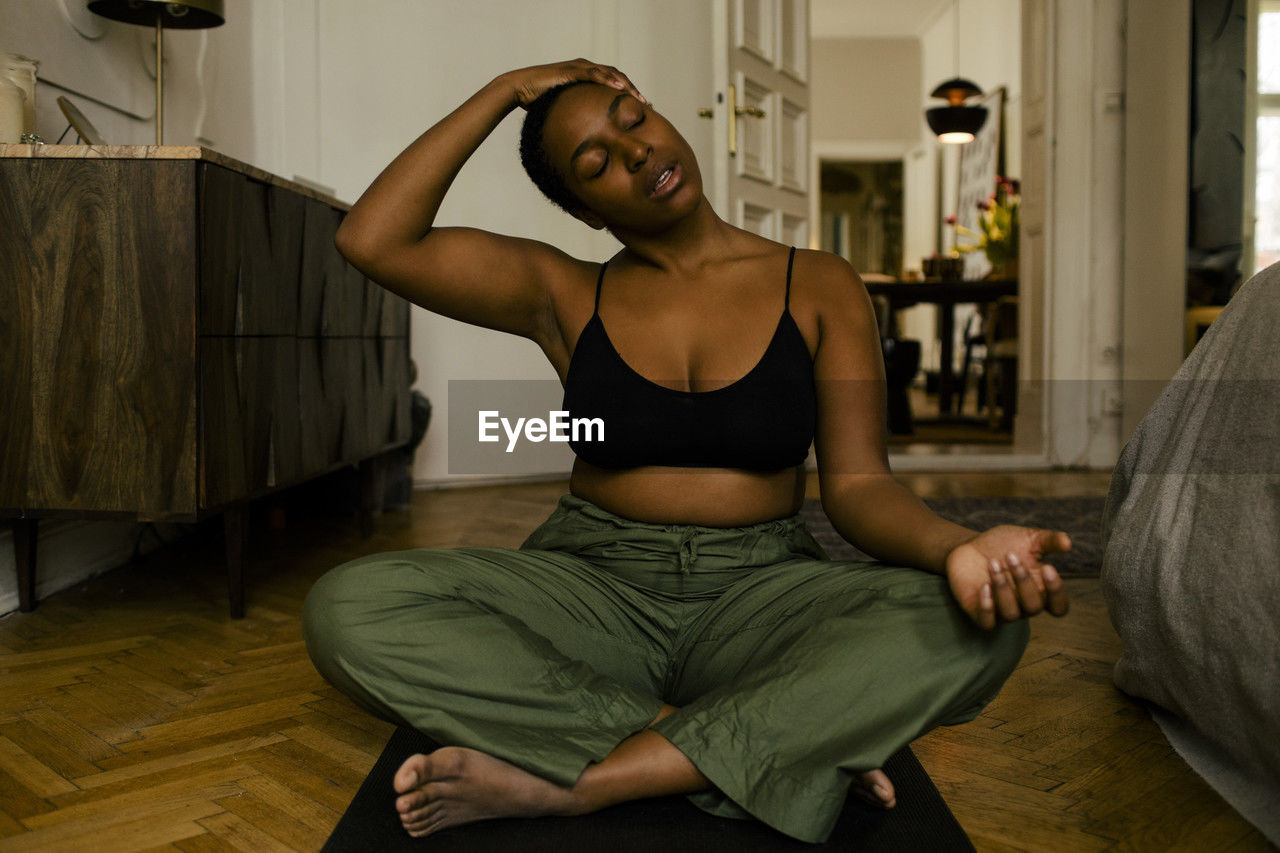 Young woman exercising on mat at home