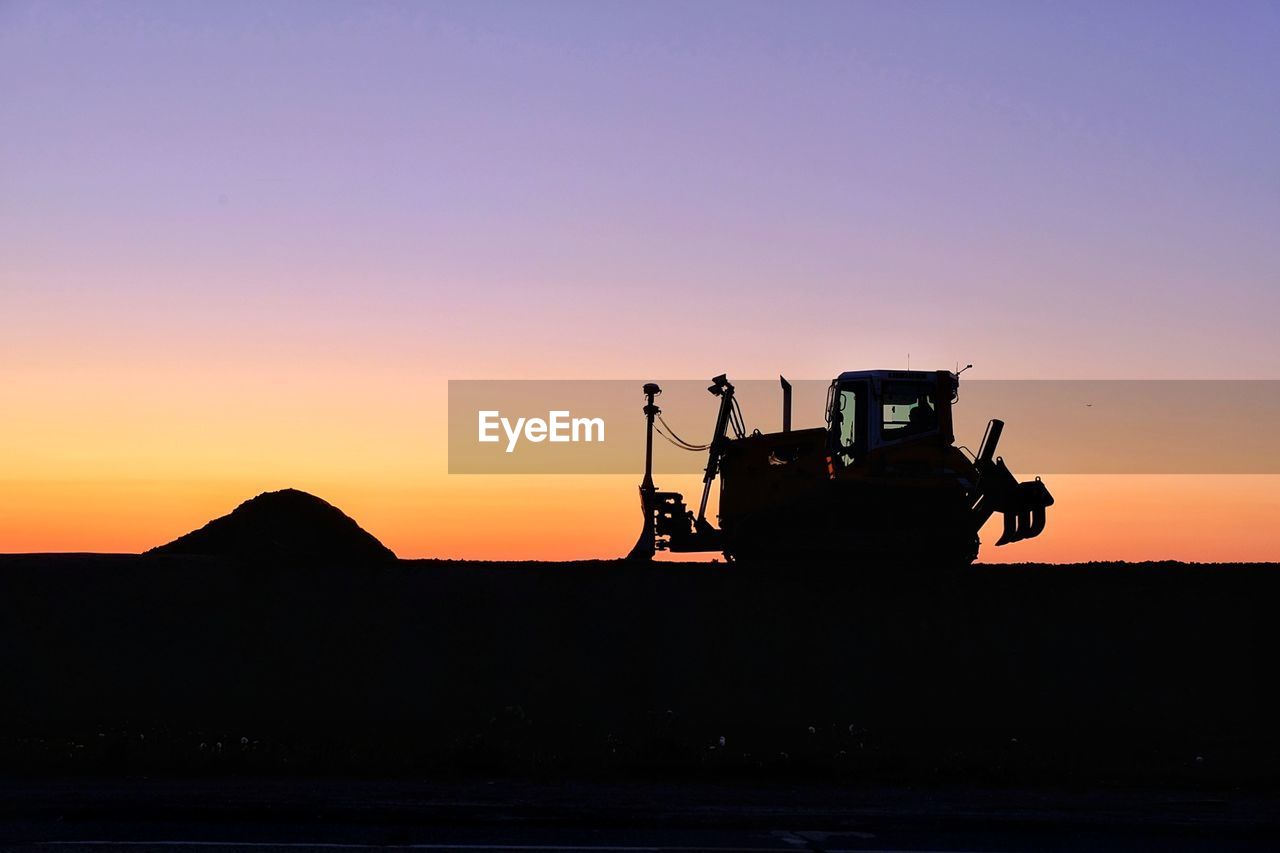 SILHOUETTE PEOPLE AT CONSTRUCTION SITE DURING SUNSET