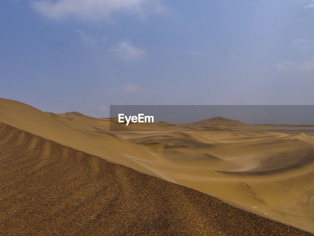 Photograph of a sand dune in the namib desert near swakopmund, namibia on a sunny dry season morning