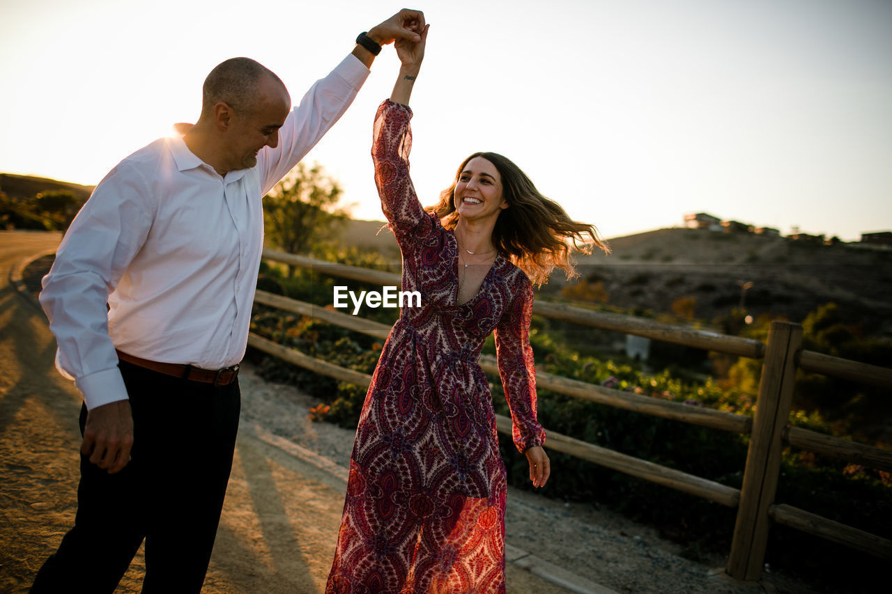 Husband and wife dancing at sunset in socal