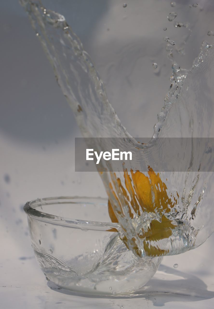 CLOSE-UP OF GLASS POURING WATER IN DRINKING GLASSES