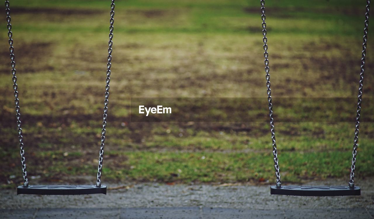 Close-up of empty swings in park