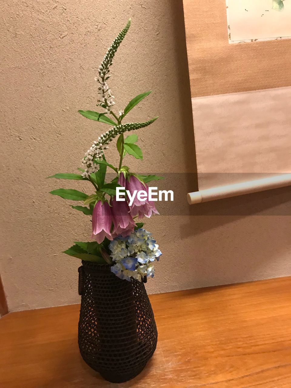 FLOWER VASE ON TABLE AGAINST WALL