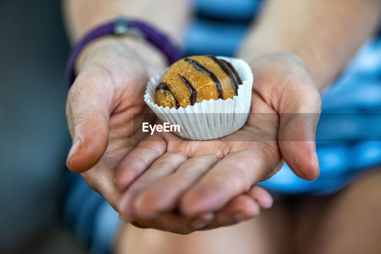 Woman hands giving sweet cake with chocolate, closeup