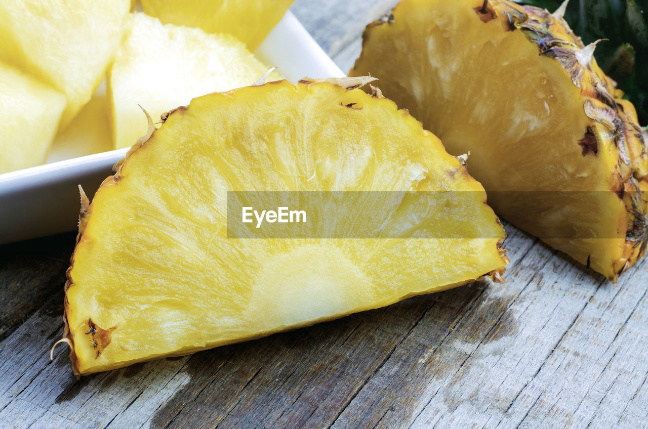 food and drink, food, plant, freshness, produce, healthy eating, fruit, dish, pineapple, yellow, no people, wellbeing, citrus, wood, indoors, close-up, still life, table, slice, cuisine, high angle view