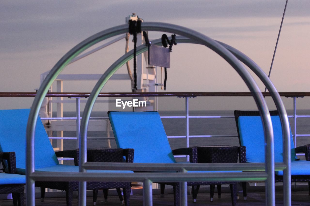 Lounge chair in boat against sky during sunset
