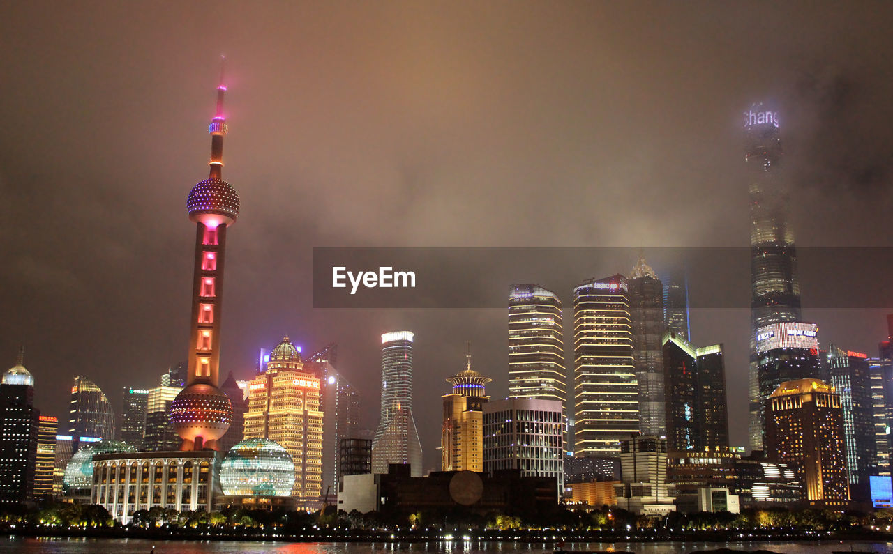 ILLUMINATED MODERN BUILDINGS IN CITY AGAINST SKY