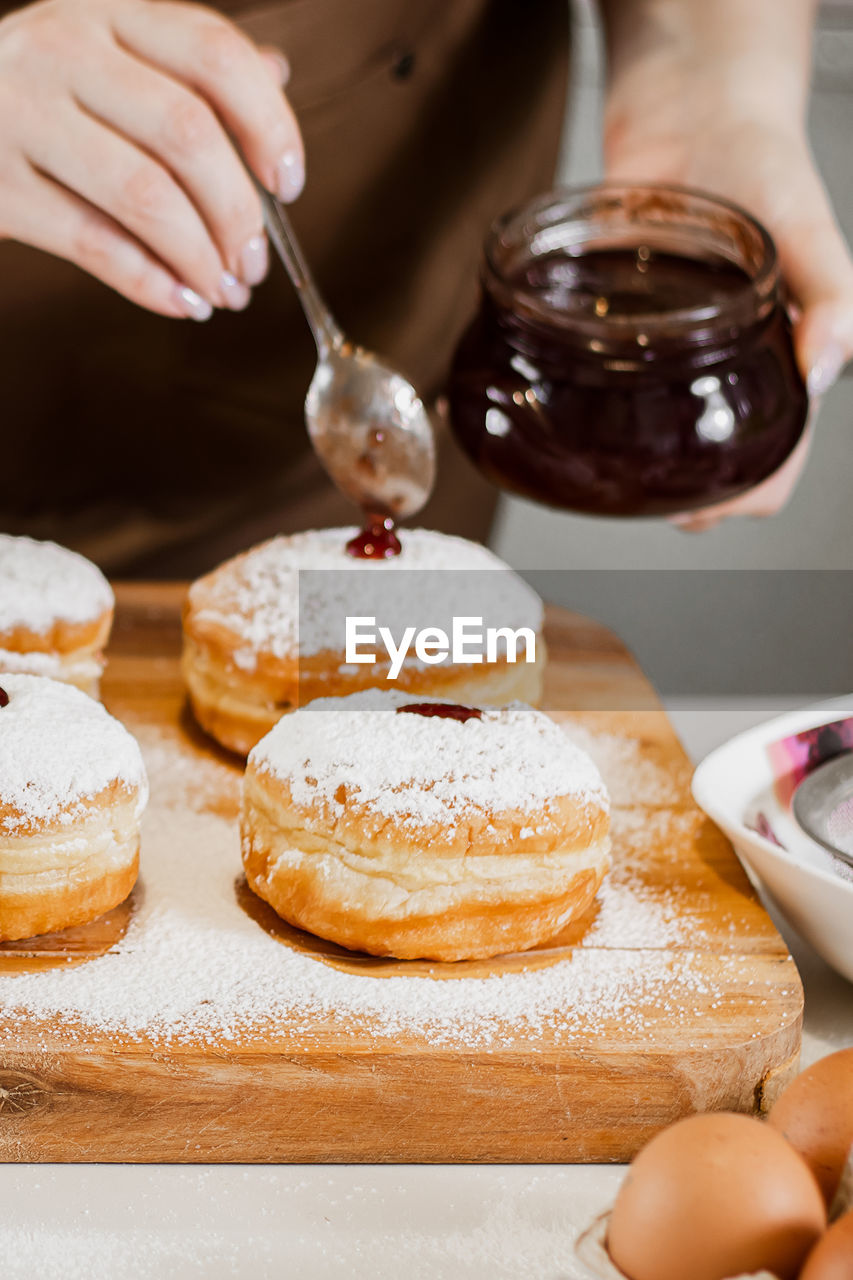 cropped hand of woman having breakfast on table