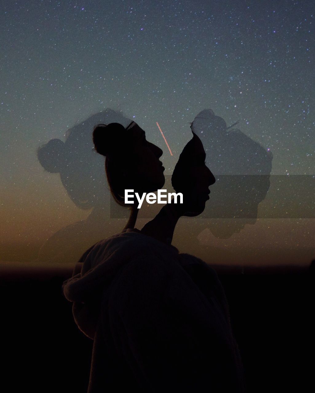 Multiple image of silhouette woman against star field at night