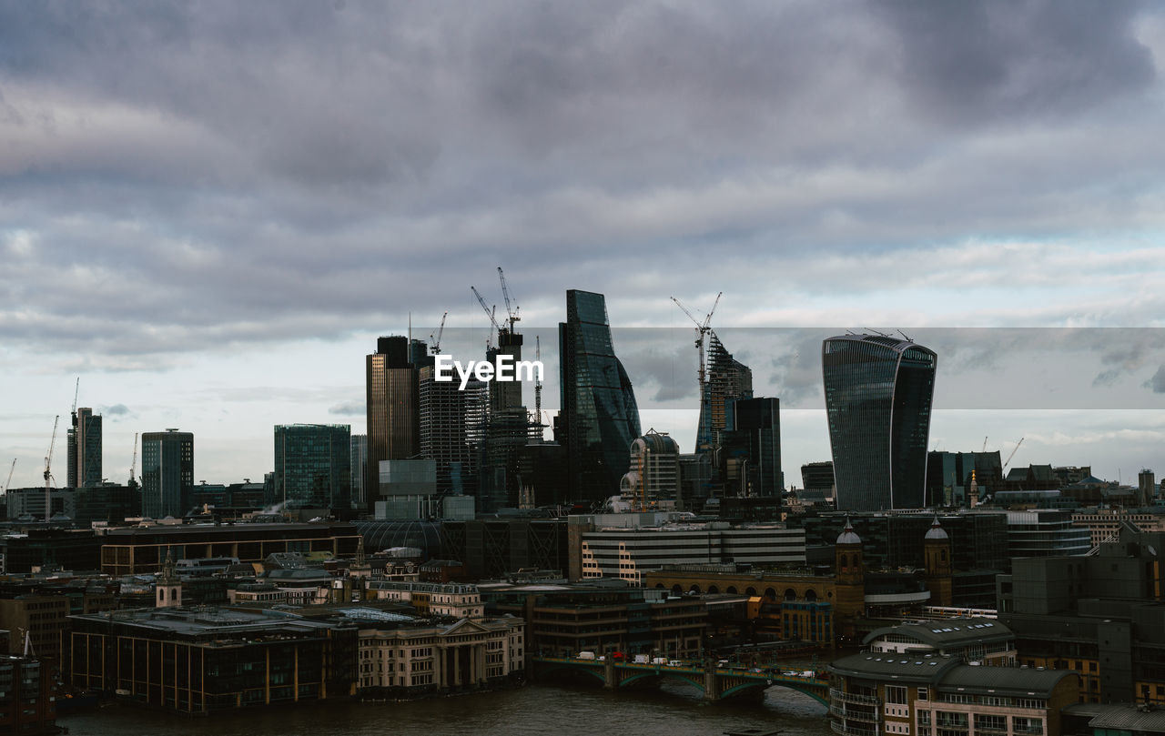 Buildings in city against cloudy sky