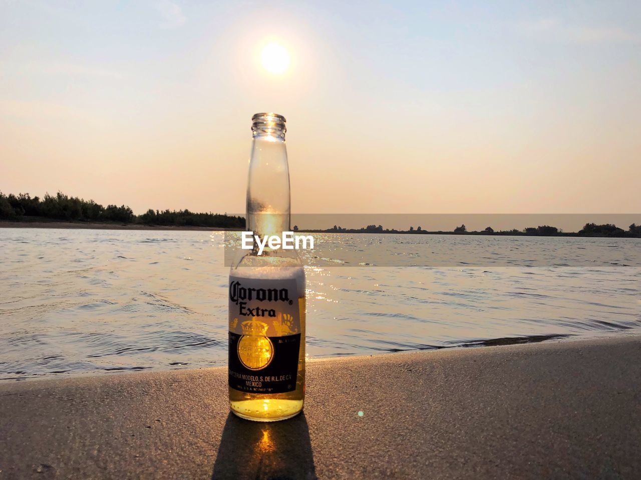 WATER BOTTLE ON BEACH DURING SUNSET