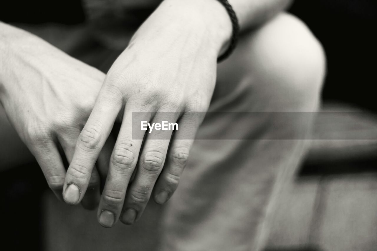 Close-up of clasped hands of young man