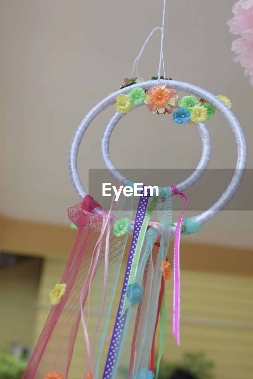 Close-up of colorful dreamcatcher hanging at home