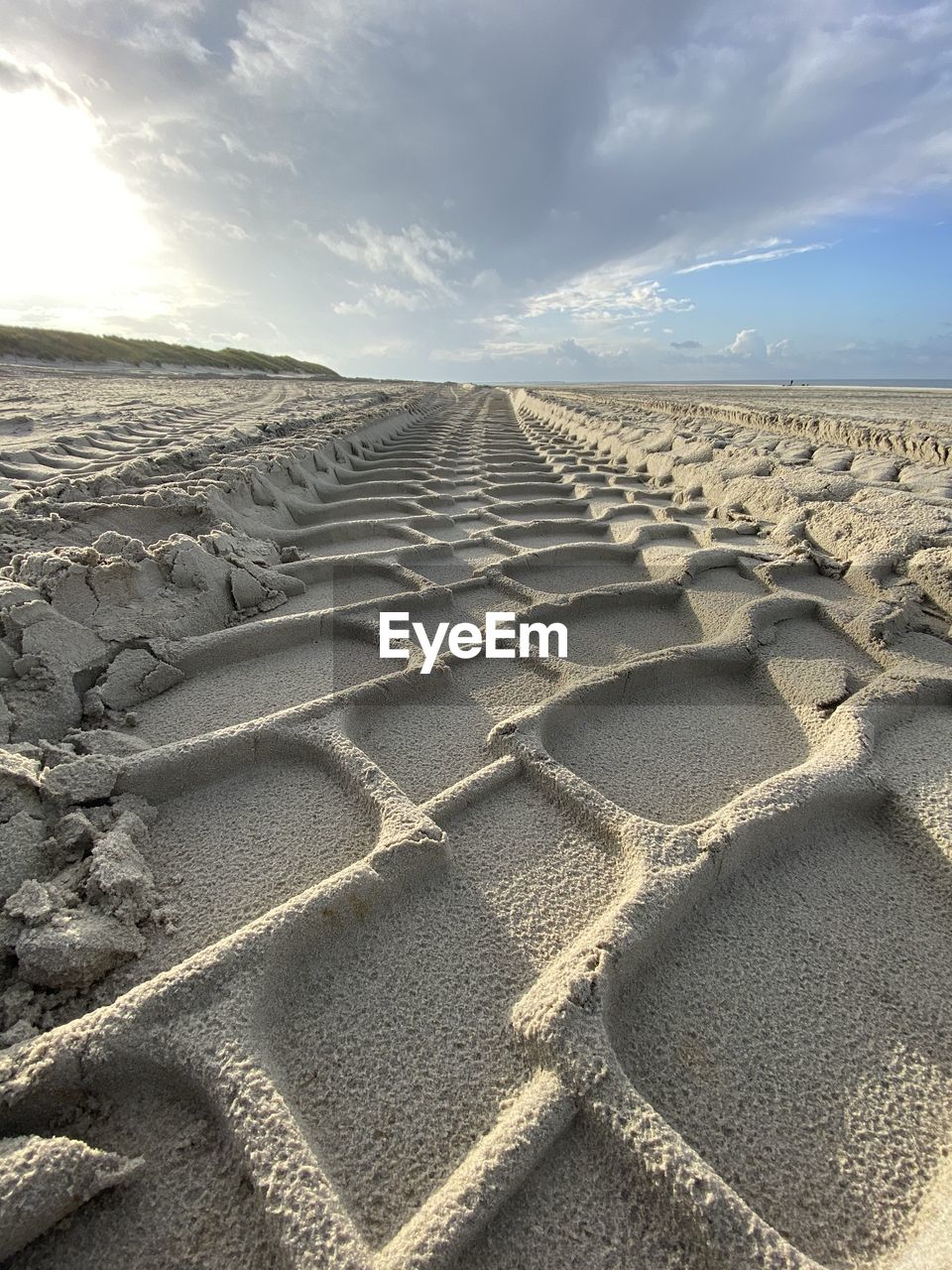 Scenic view of sand dune on beach against sky