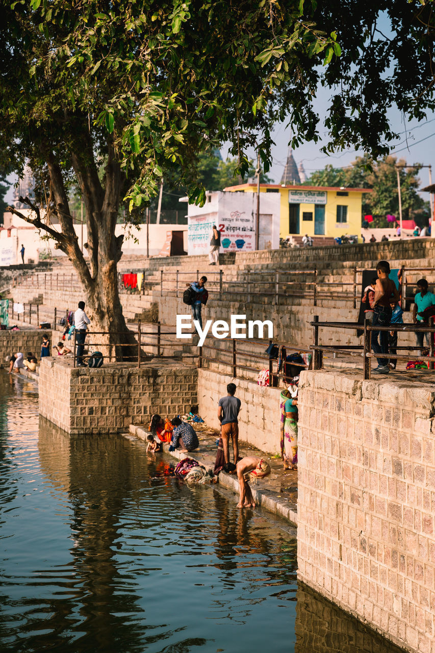 PEOPLE IN CANAL BY BUILDINGS