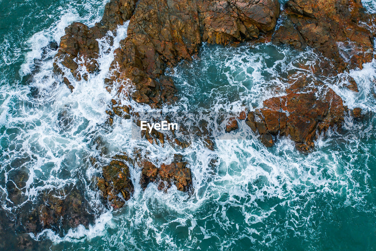 High angle view of water splashing on rocks