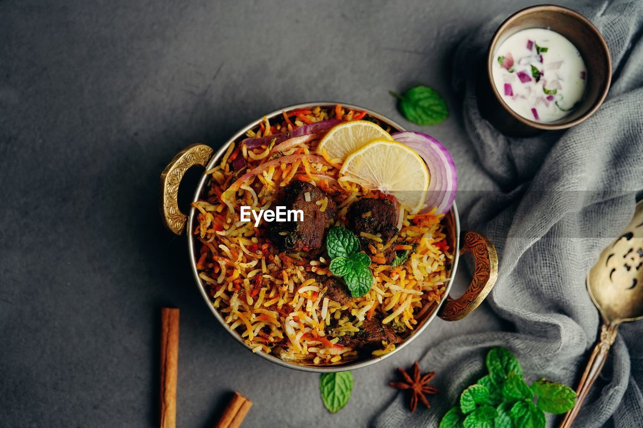 Mutton goat biryani  served with yogurt raita overhead view