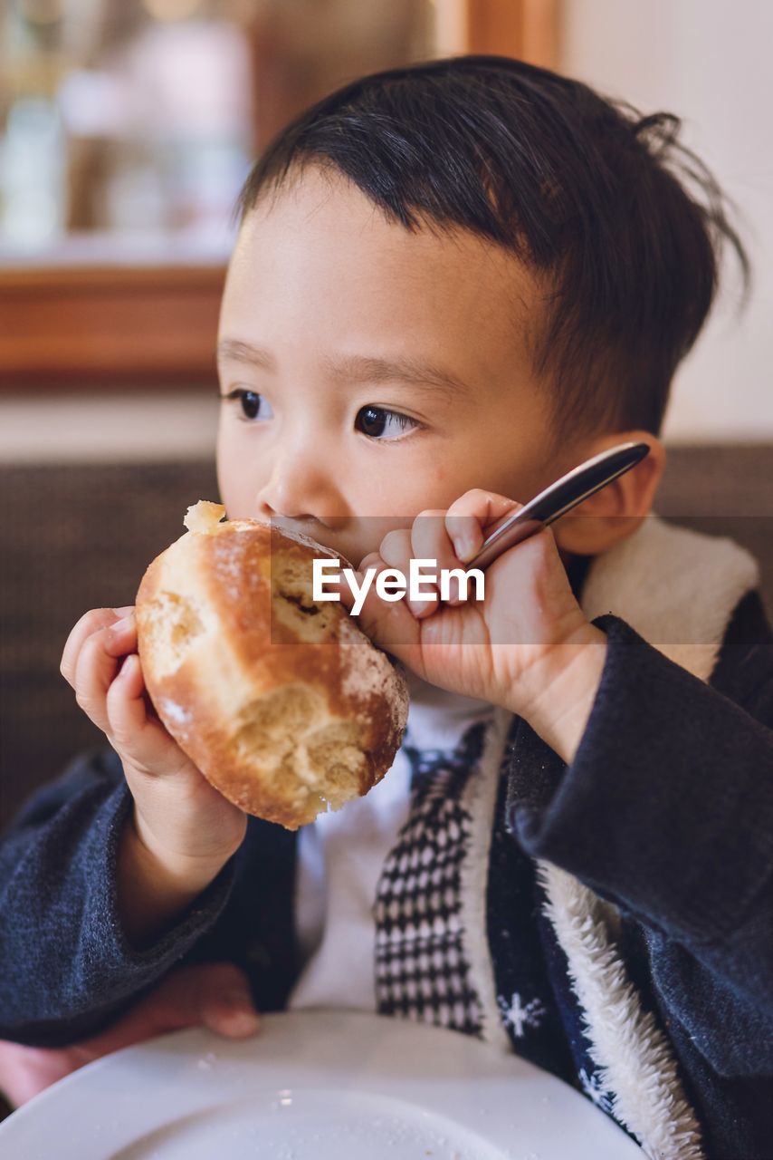 Portrait of boy eating a donut 