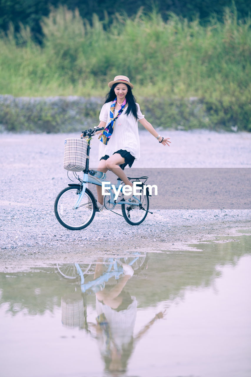Woman cycling by puddle