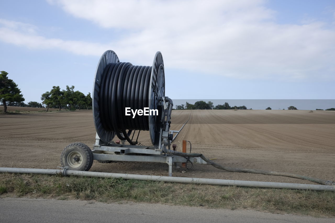 AGRICULTURAL VEHICLE ON FIELD AGAINST SKY