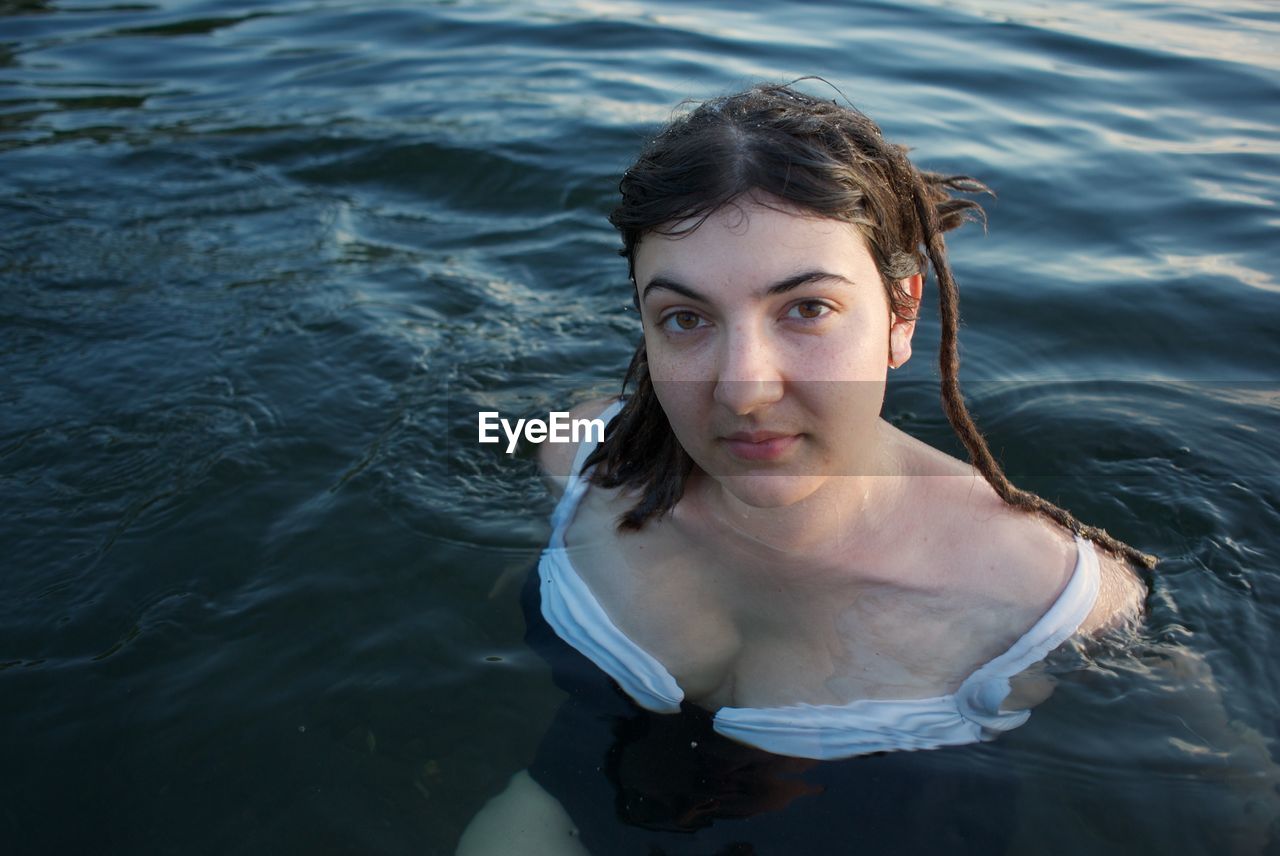 PORTRAIT OF YOUNG WOMAN SWIMMING IN SEA