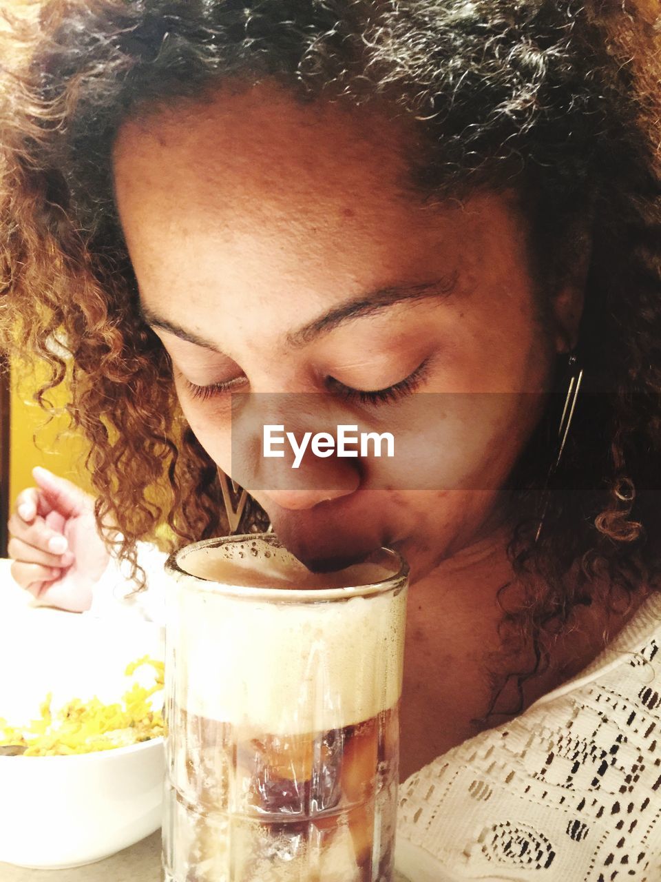 CLOSE-UP OF A YOUNG WOMAN DRINKING GLASS WITH DRINK