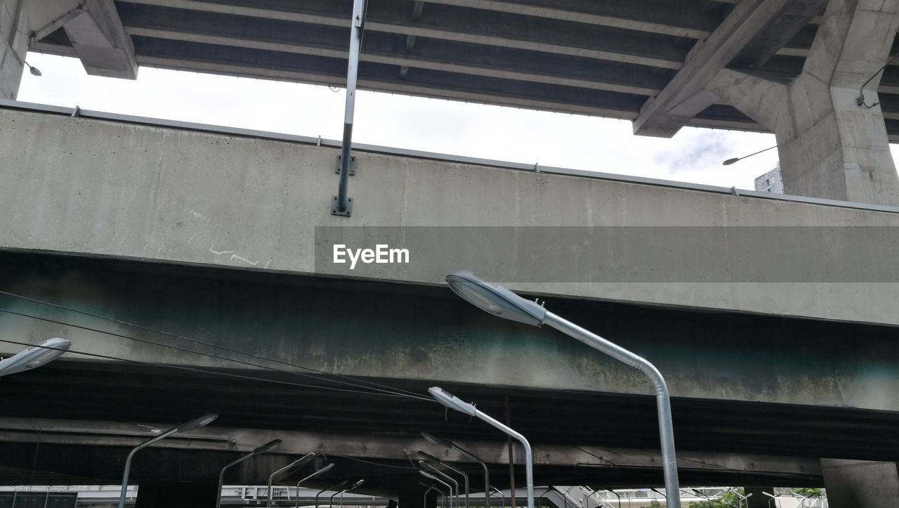 LOW ANGLE VIEW OF BUILDING SEEN THROUGH METAL STRUCTURE