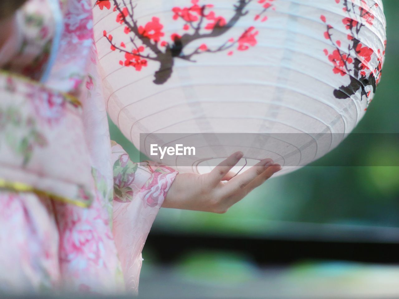 Midsection of woman holding paper lantern