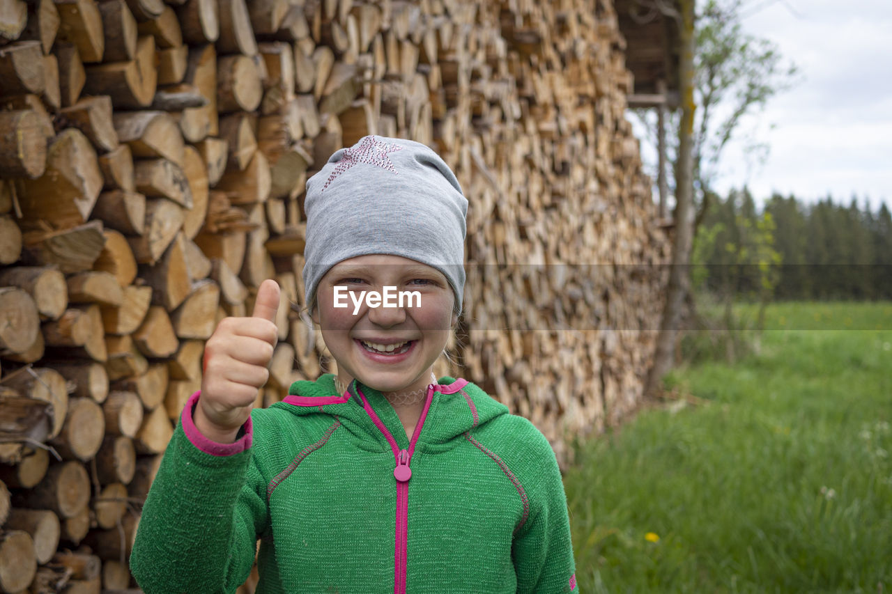 Portrait of smiling boy standing against stone wall