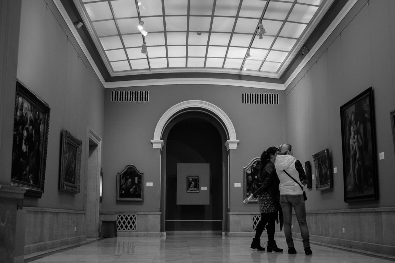 REAR VIEW OF MAN STANDING AT MUSEUM