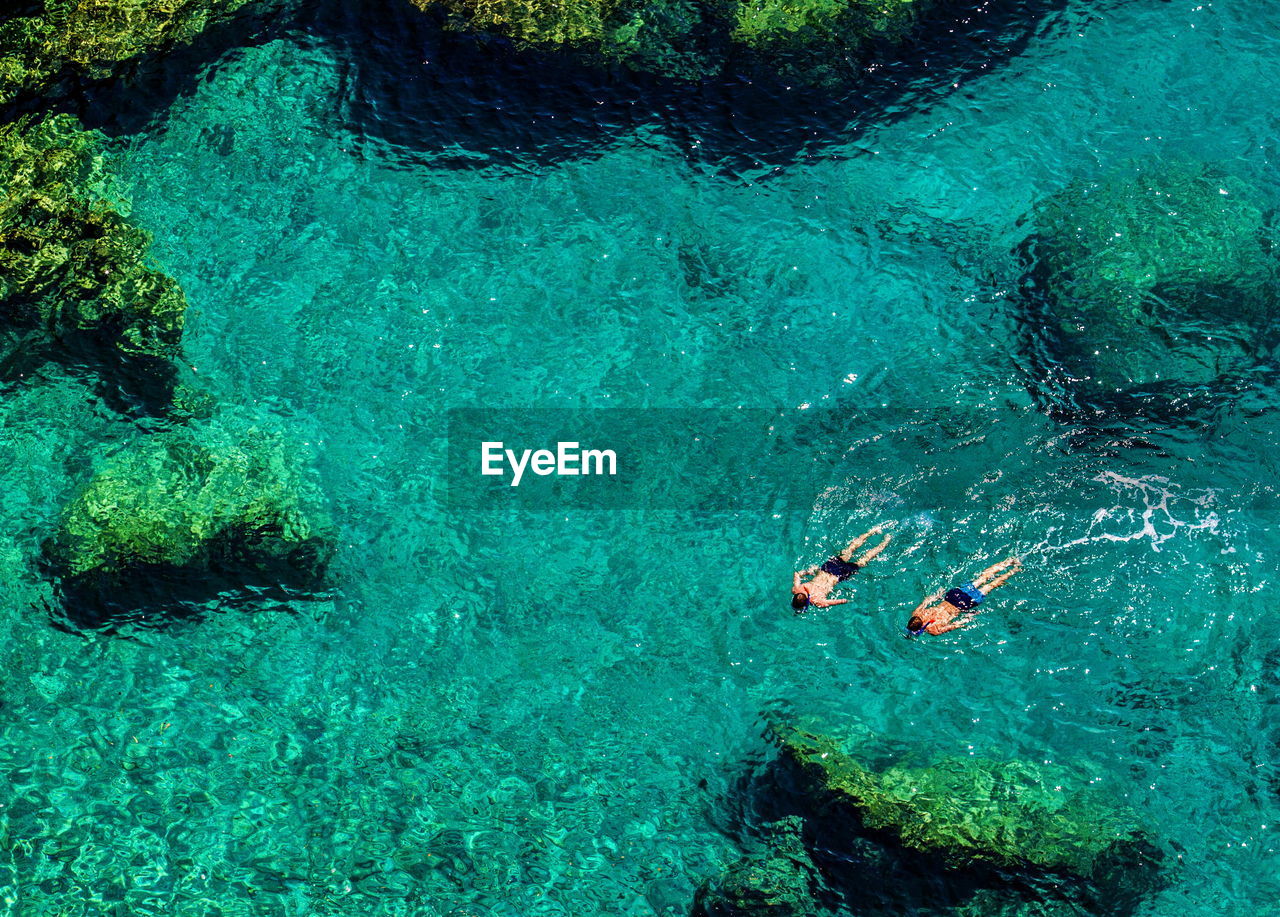 High angle view of men swimming in sea