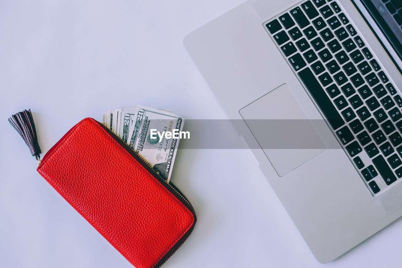 High angle view of laptop with money on white background