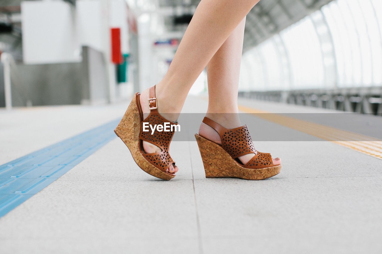 Low section of woman standing on tiled floor