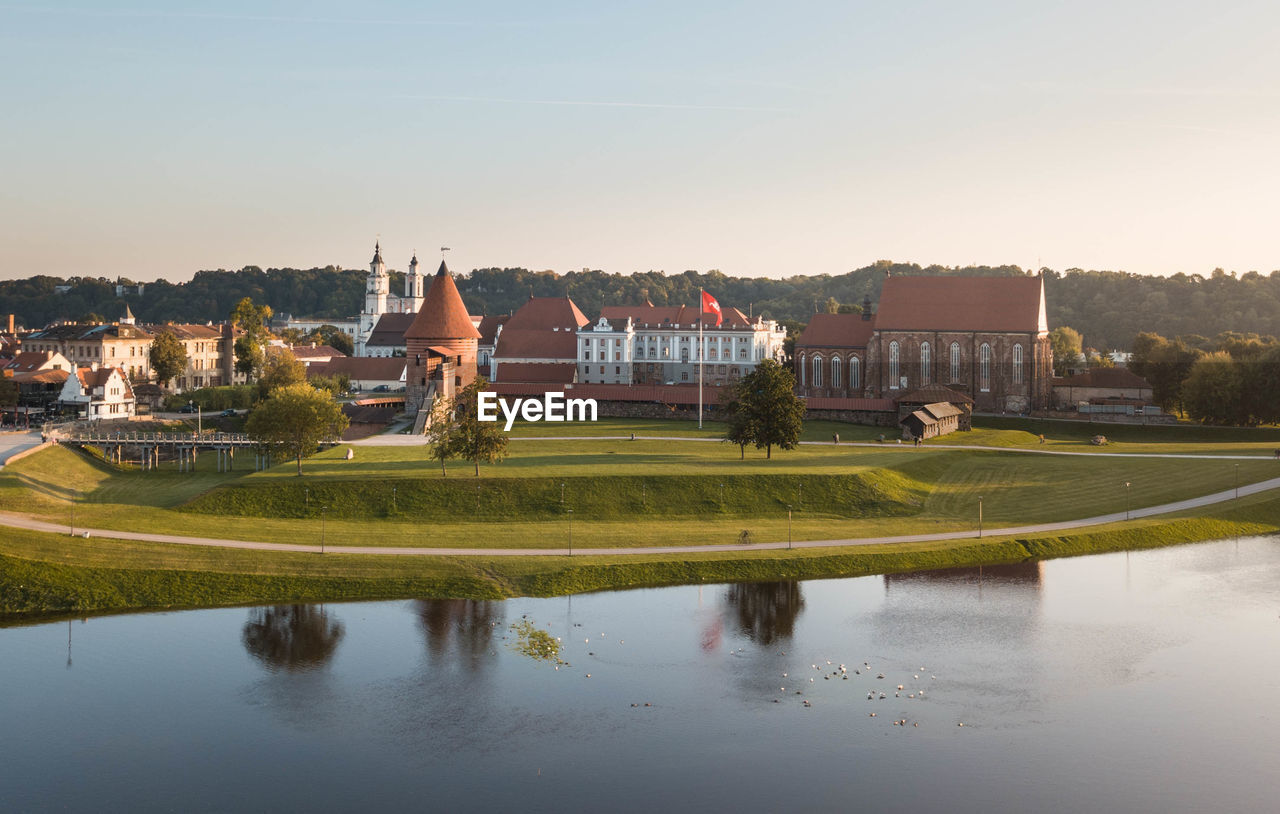 SCENIC VIEW OF LAKE BY BUILDINGS AGAINST SKY IN CITY