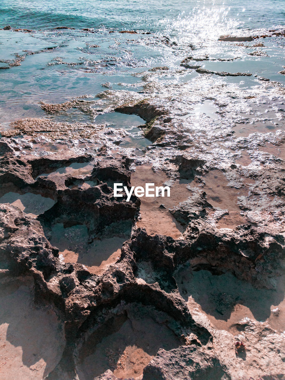 HIGH ANGLE VIEW OF ROCKS ON SEA