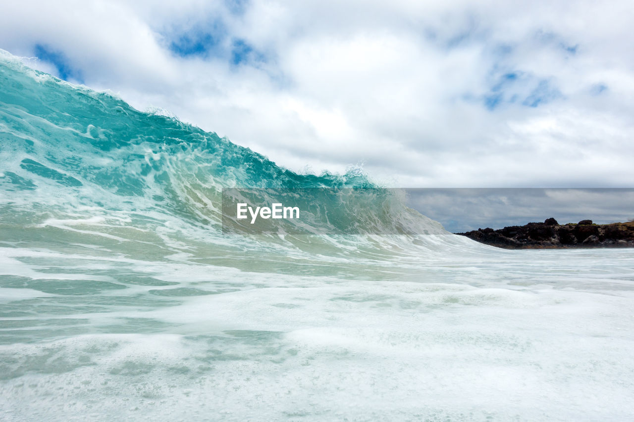 SCENIC VIEW OF SEA BY WAVES AGAINST SKY