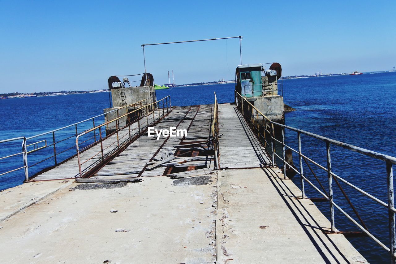 RAILING BY SEA AGAINST CLEAR BLUE SKY