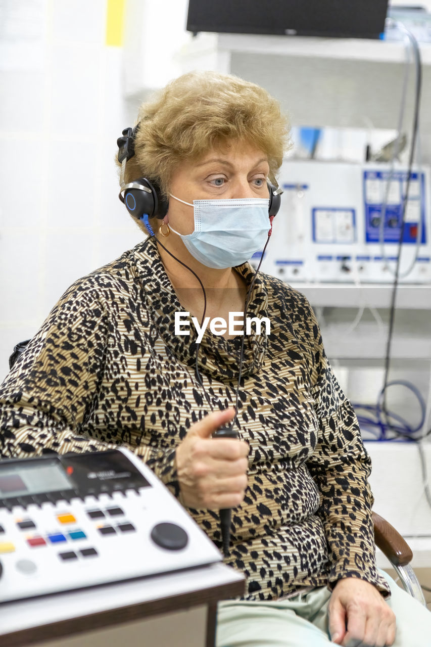 Audiologist checks the hearing of an older woman