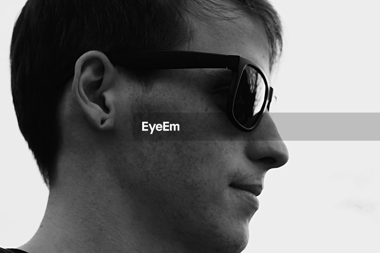 Close-up of young man in sunglasses looking away