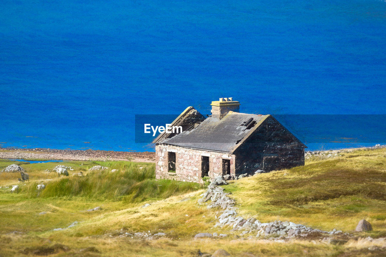 HOUSE ON FIELD AGAINST SKY